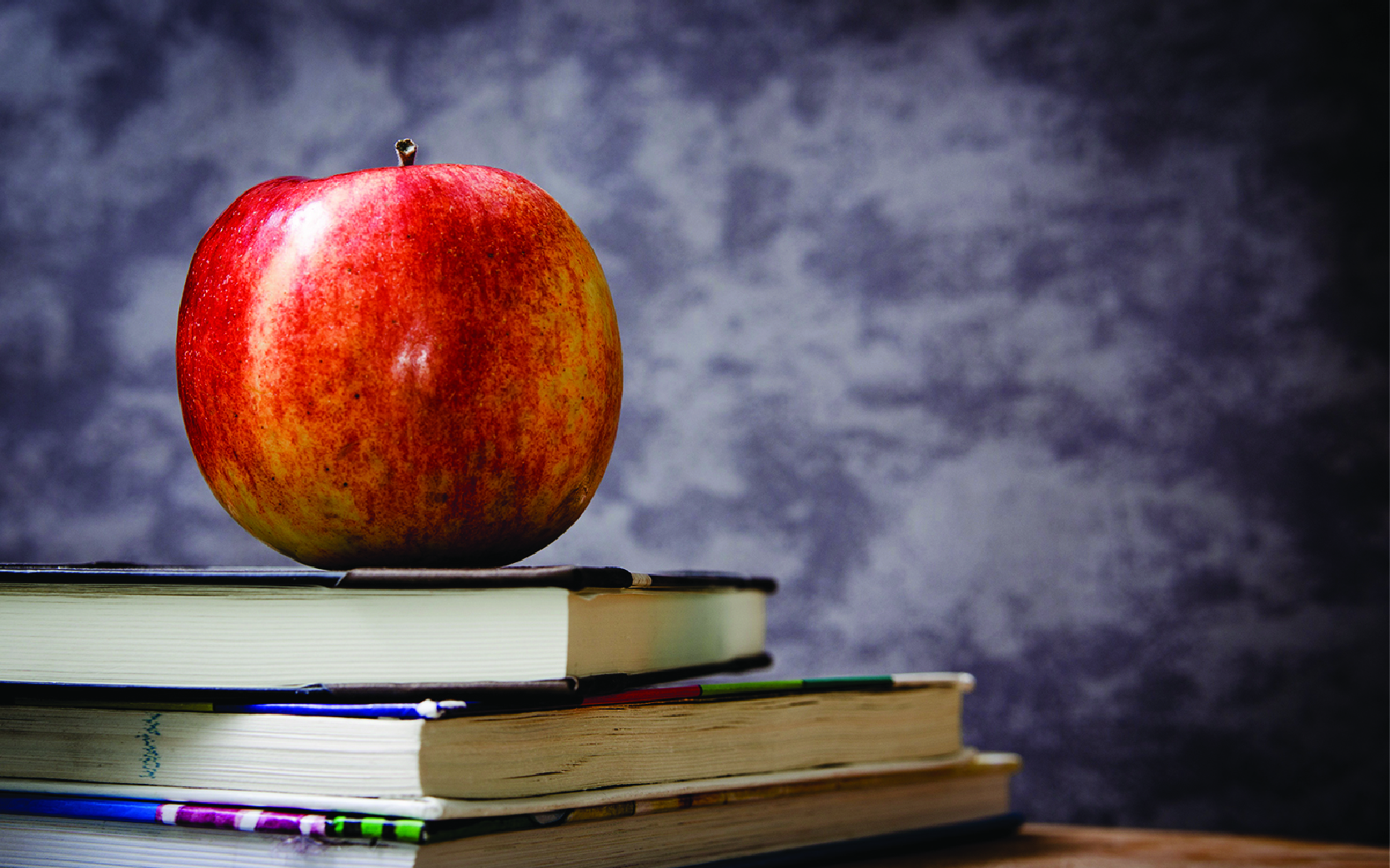 apple and two books on desk