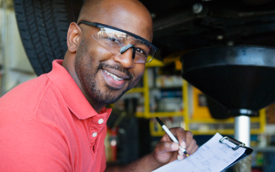 a male mechanic holding a clipboard