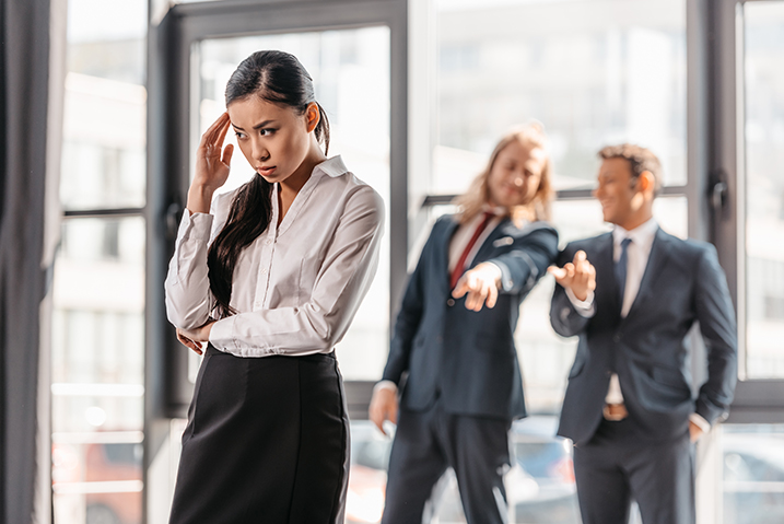 two men pointing at a female employee